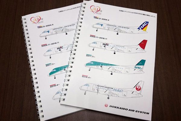 北海道エアシステム、会社設立20周年で記念品配布　歴代塗装のリングノート